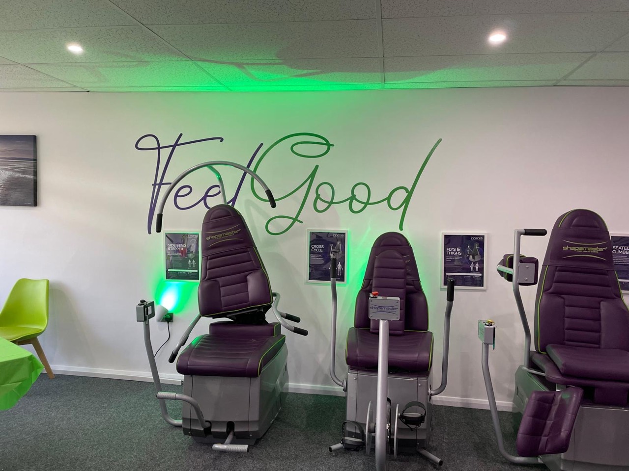 The Feel Good West Meads studio with purple exercise machines and the Feel Good wall sign
